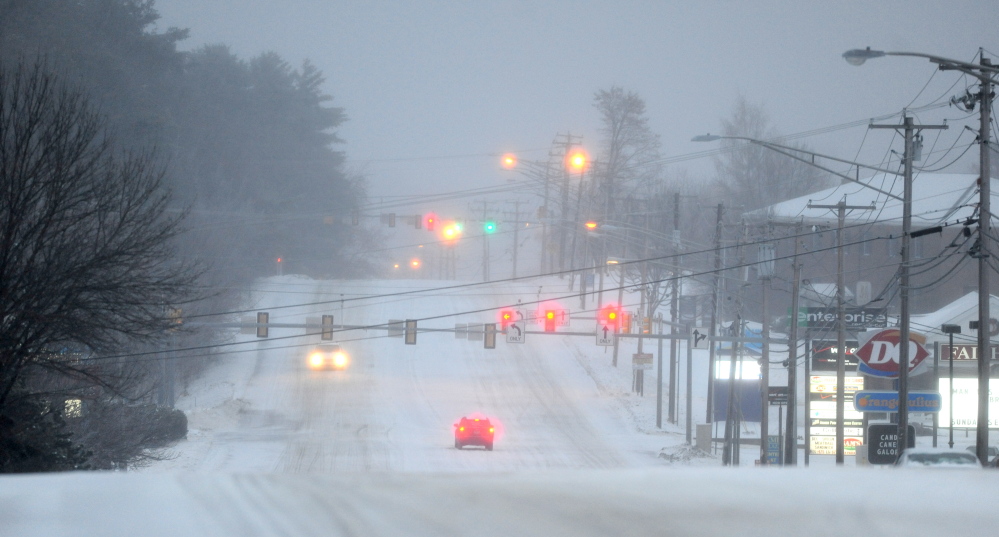 ICEY DICEY: Traffic moves slowly on Kennedy Memorial Drive in Waterville early Sunday morning as a major ice storm grips the area.