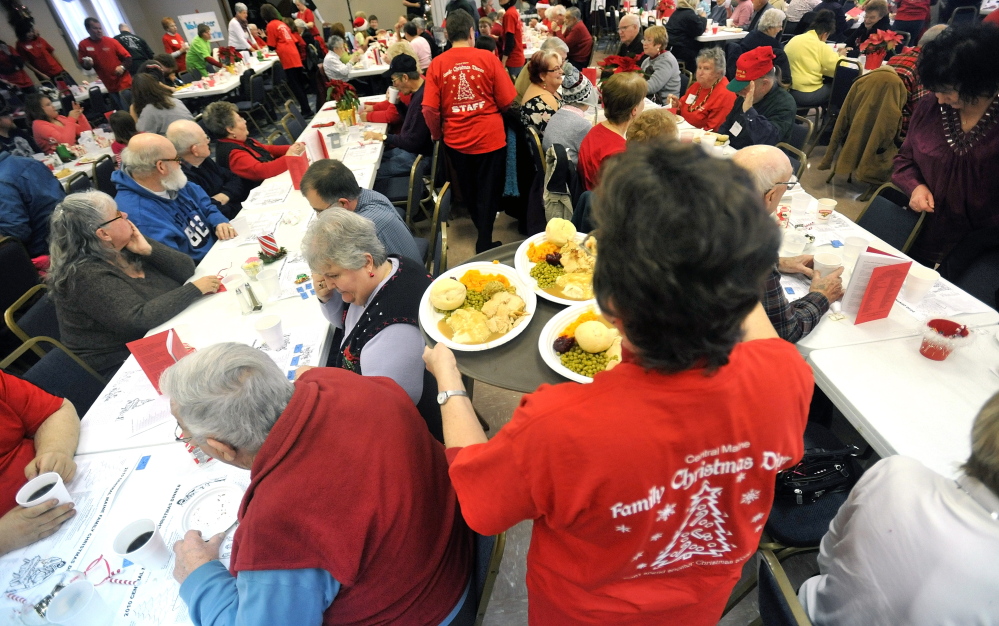 Annual Event: A volunteer delivers meals to people at a previous Central Maine Family Christmas Dinner at the Elks Lodge in Waterville.
