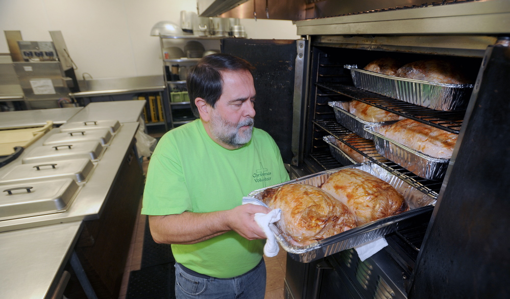 CHRISTMAS DINNER: Richard Dionne, kitchen supervisor for the Central Maine Family Christmas Dinner, tends to turkey in the oven at the Elks Lodge in Waterville on Monday. This will be the seventh consecutive year that volunteers have offered a free dinner open to all on Christmas Day.