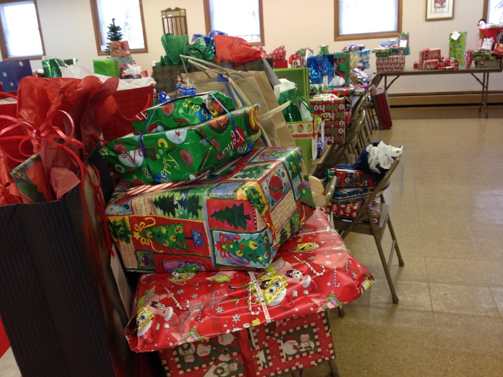 Wishes granted: Presents awaiting pickup by caseworkers for the Maine Department of Health and Human Services line tables at Sacred Heart Parish Hall in Hallowell Monday morning. The presents, largely bought by parishioners of three Hallowell churches, will be given to families in need before Christmas.