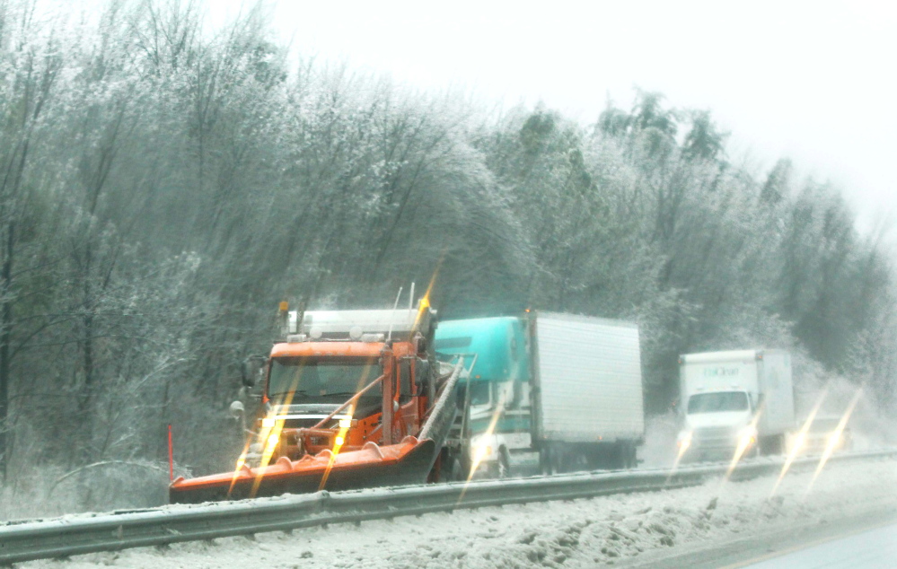Photo by Jeff Pouland CLEARING THE WAY: A plow truck works to clear the northbound lane of Interstate 95 in Augusta during Monday's storm.