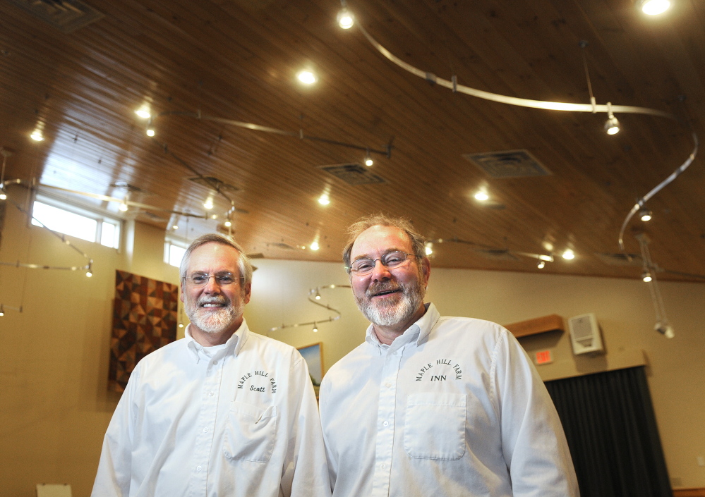 CHAMBER AWARD: Scott Cowger, left, and Vince Hannan stand beneath mercury-free LED lights they installed in the “Gathering Place” room at their eco-friendly Hallowell inn, Maple Hill Farm. The couple are being recognized by the Chamber of Commerce with the President’s Award.