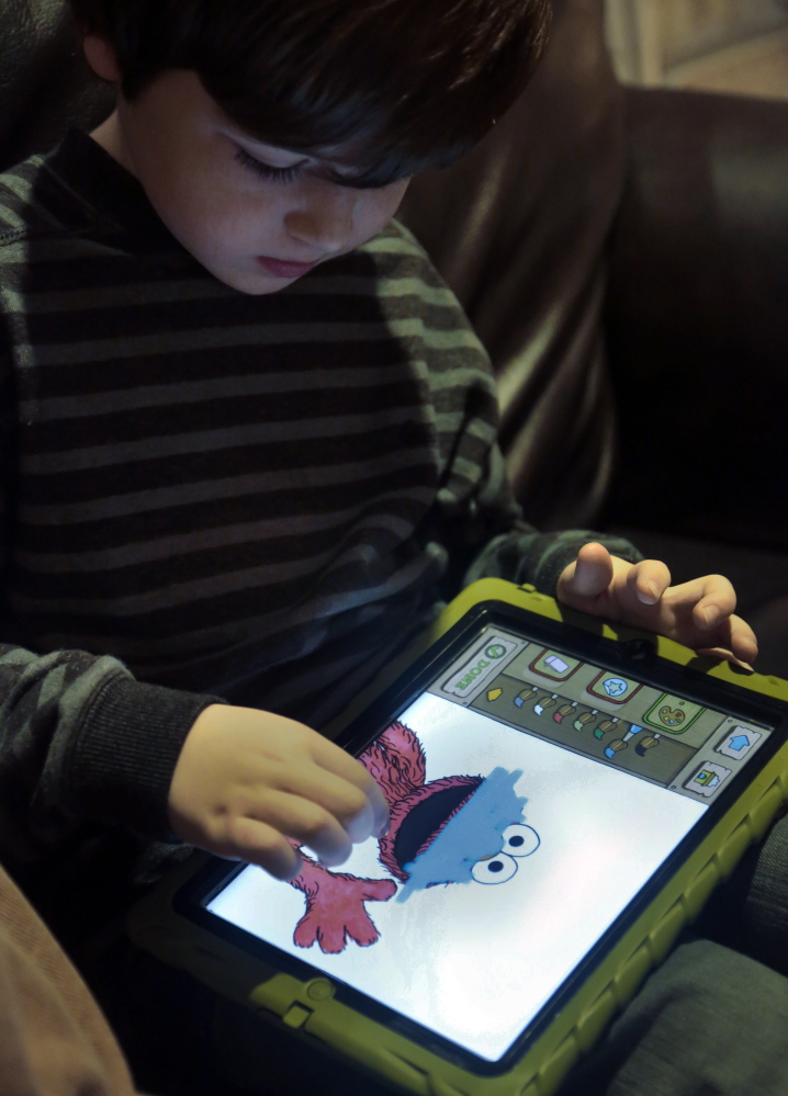 Marc Cohen uses a Sesame Street app on his tablet at home in New York.