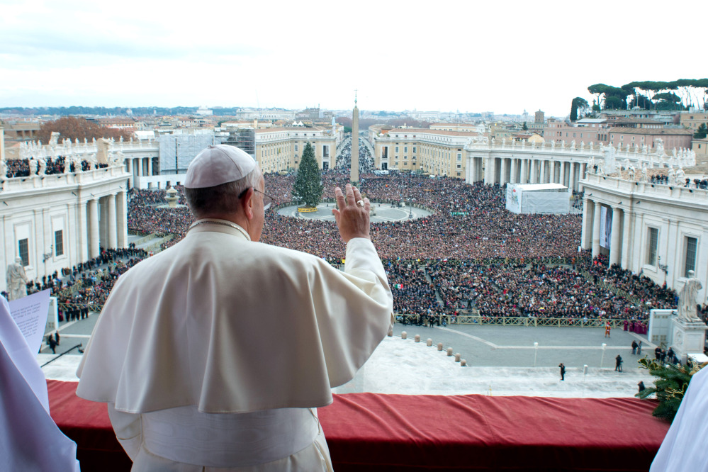 In this picture provided by the Vatican newspaper L’Osservatore Romano, Pope Francis delivers his “Urbi et Orbi” (to the City and to the World) message from the central balcony of St. Peter’s Basilica at the Vatican, Wednesday, Dec. 25, 2013. Pope Francis on Christmas day is wishing for a better world, with peace for the land of Jesus’ birth, for Syria and Africa as well as for the dignity of migrants and refugees fleeing misery and conflict. Francis spoke from the central balcony of St. Peter’s Basilica Wednesday to tens of thousands of tourists, pilgrims and Romans in the square below. He said he was joining in the song of Christmas angels with all those hoping “for a better world,” and with those who “care for others, humbly.”