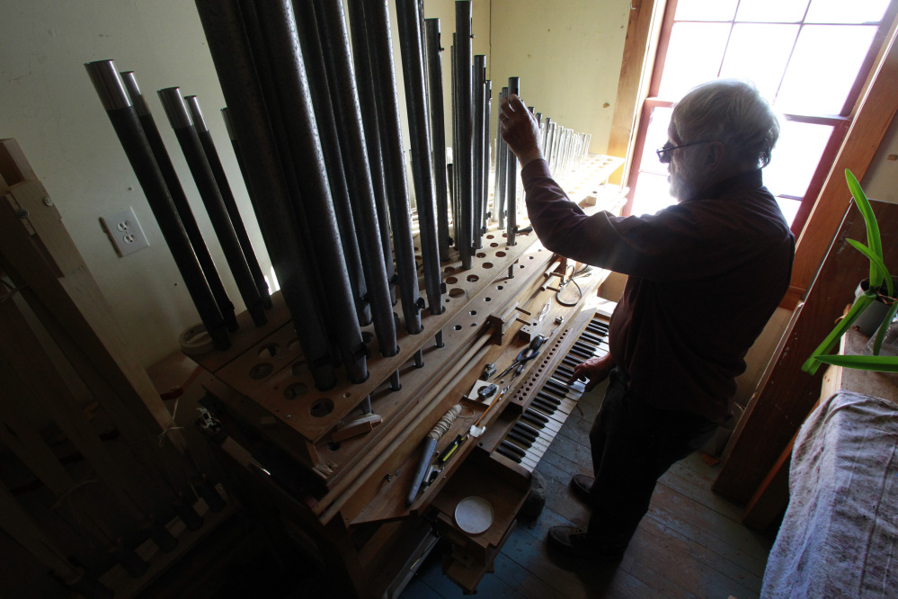 David Moore tunes the pipes on one of the organs he’s restoring at his facility, a converted barn in Vermont.