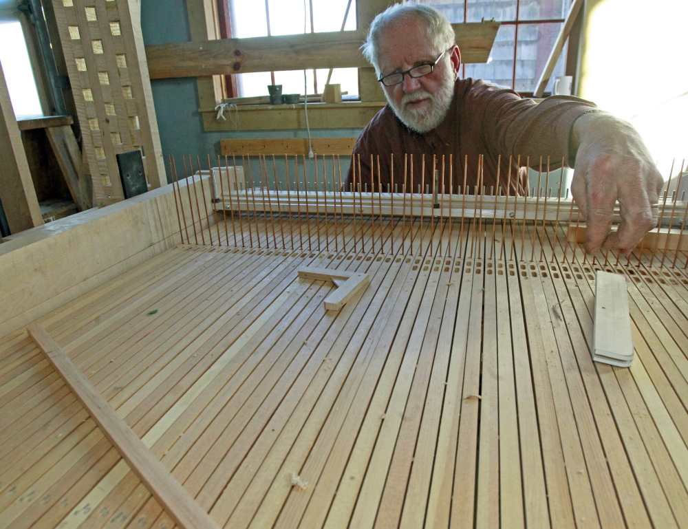 David Moore works on an organ at A. David Moore, Inc., an organ restoration company in Pomfret, Vt. Moore and his six employees generally adhering to a 19th-century construction style when renovating pipe organs, but they use modern-day technology to power the blowers, which provide air to produce the sound.