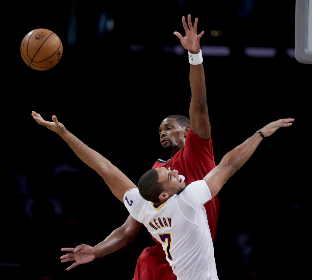 BIG NIGHT: Miami Heat center Chris Bosh, top, blocks a shot by Los Angeles Lakers forward Xavier Henry during the second half of their game Wednesday in Los Angeles. The Heat won 101-95.