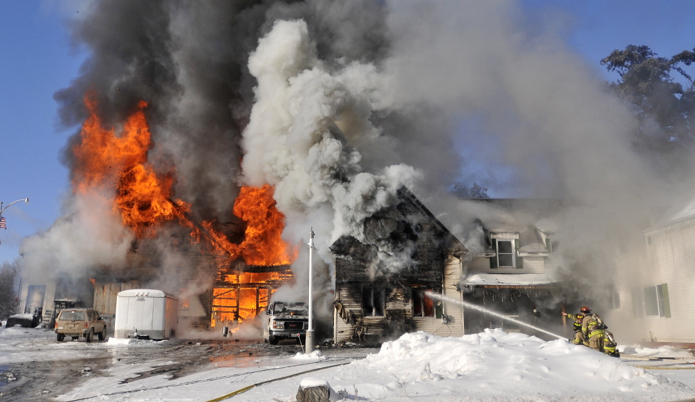 Staff photo by Michael G. Seamans CHRISTMAS FIRE: Firefighters from Waterville battle a blaze at 160 Drummond Ave. in Waterville on Wednesday.
