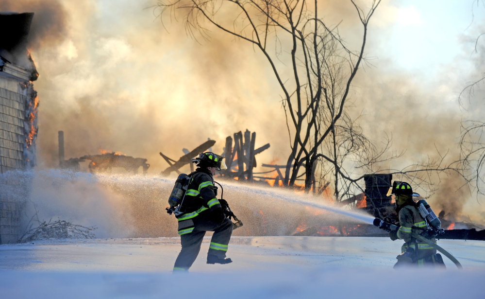 Staff photo by Michael G. Seamans CHRISTMAS FIRE: Fairfield firefighters battle a fire at 160 Drummond Ave. in Waterville on Wednesday.
