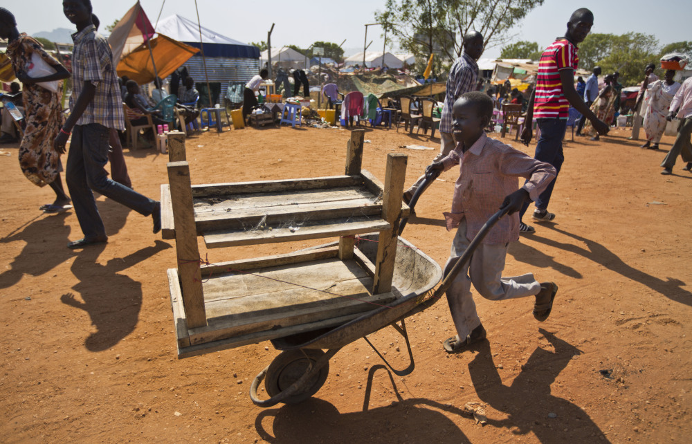 A displaced boy uses a wheelbarrow to transport belongings inside a United Nations compound which has become home to thousands of people displaced by the recent fighting, in Juba, South Sudan Friday, Dec. 27, 2013. Kenya’s president Uhuru Kenyatta on Friday urged South Sudan’s leaders to resolve their political differences peacefully and to stop the violence that has displaced more than 120,000 people in the world’s newest country, citing the example of the late Nelson Mandela and saying there is “a very small window of opportunity to secure peace” in the country where fighting since Dec. 15 has raised fears of full-blown civil war.