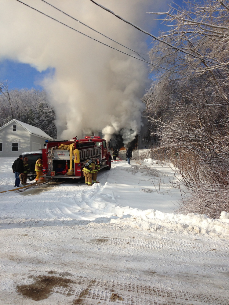 FIRE RESPONSE: Crews respond to a fire at Fire Road 14 in China Friday morning. Homeowner Neil Farrington saved his disabled brother-in-law from the blaze, but the home was a loss.