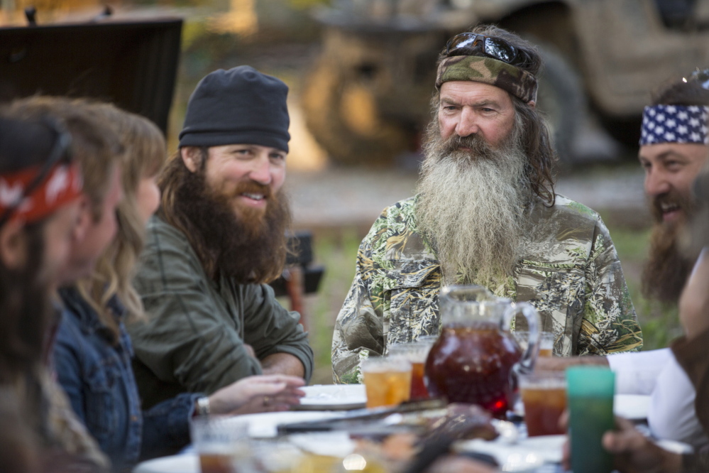 This undated image released by A&E shows Phil Robertson, flanked by his sons Jase Robertson, left, and Willie Robertson from the popular series “Duck Dynasty.” Phil Robertson was suspended for disparaging comments he made to GQ magazine about gay people but was reinstated by the network on Friday, Dec. 27. In a statement Friday, A&E said it decided to bring Robertson back to the reality series after discussions with the Robertson family and “numerous advocacy groups.”