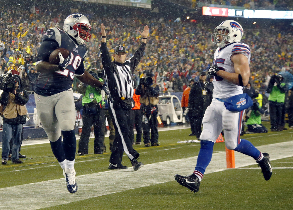 New England Patriots running back LeGarrette Blount (29) scores a touchdown past Buffalo Bills safety Jim Leonhard (35) in the second quarter of an NFL football game, Sunday, Dec. 29, 2013, in Foxborough, Mass. (AP Photo/Elise Amendola)