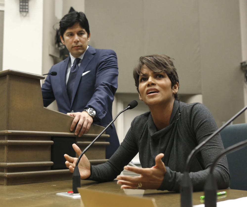 In this Aug. 13, 2013, file photo, actress Halle Berry urges lawmakers to support a bill that would limit the ability of paparazzi to photograph children of celebrities and public figures, at the Capitol in Sacramento, Calif. The bill, by state Sen. Kevin de Leon, D-Los Angeles, left, was approved by the Legislature and signed by Gov. Jerry Brown, is one of the more than 800 new laws to take effect Jan. 1.