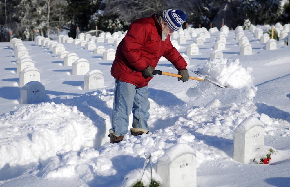 TUNNEL OF LOVE: Paul Drouin shovels a path Monday to the grave of his wife, Patricia, at the Maine Veterans Memorial Cemetery in Augusta. “She was more than my wife,” the 74-year-old who visits twice a day said. “She was my best friend.”