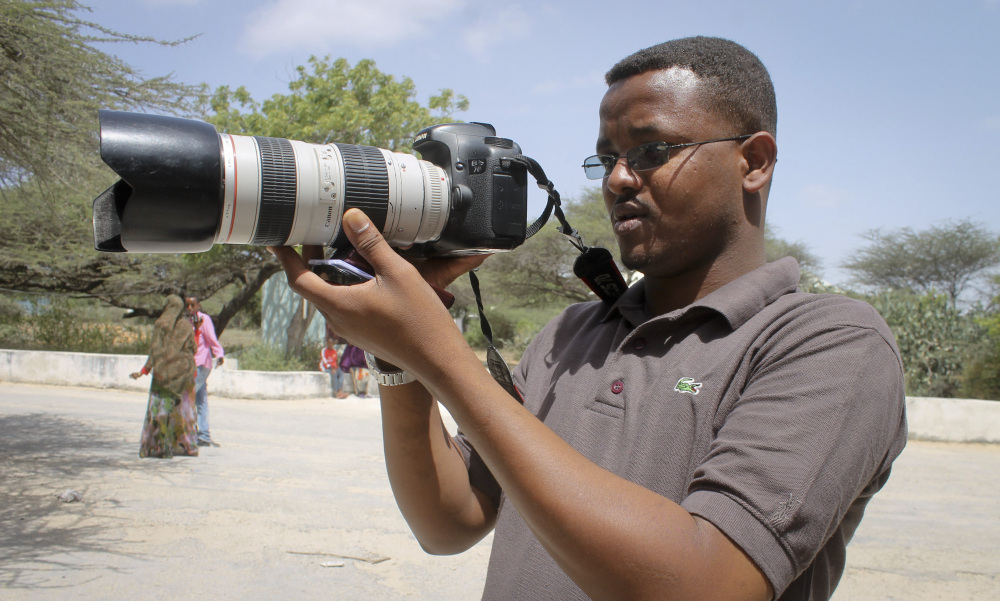 In this photo taken Friday, Jan. 18, 2013, Somali journalist Mohamed Mohamud holds his camera in the Medina hospital compound in Mogadishu, Somalia. Mohamud was among the at least 70 journalists killed on the job around the world in 2013, including 29 who died covering the civil war in Syria and 10 slain in Iraq, according to the Committee to Protect Journalists.