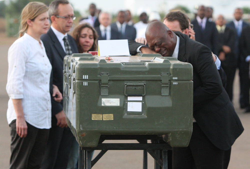 This Nov. 4, 2013 file photo shows Serge Daniel, right, Mali correspondent for Radio France Internationale weeping as he pays his last respects at the coffin of one of the two French journalists kidnapped and executed in northern Mali.