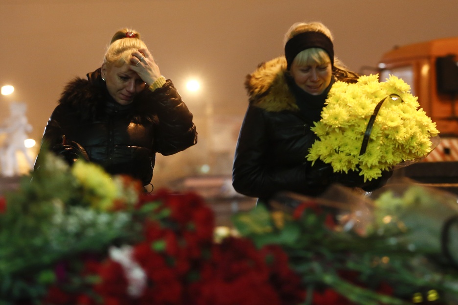 Women cry as they lay flowers outside the Volgograd main railway station in Volgograd, Russia, early Monday. Russian authorities ordered police to beef up security at train stations and other facilities across the country after two bombing attacks in two days in the southern city of Volgograd.