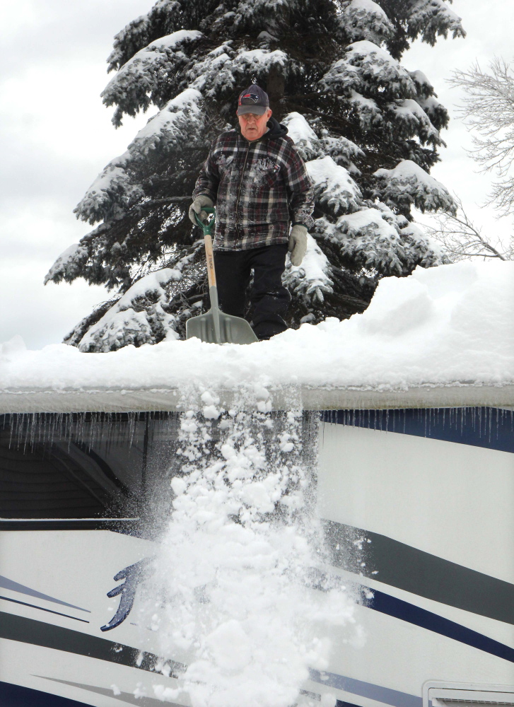 CLEARING THE ROOF: Eric Blier of Waterville clears snow off the roof of his motor home that fell during Sunday night’s storm next to his house on Cool Street in Waterville on Monday. Blier said he measured 14 inches of snow on top of his roof. Blier’s wife, Carol, said the couple would normally be in Florida right now, but because she’s battling cancer, they hope to get down there in the next month or so. “I wanted to get up there and help, but he wouldn’t let me,” said Carol.