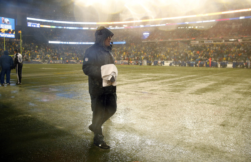New England Patriots head coach Bill Belichick walks along the sideline of a rain-drenched field in the fourth quarter of an NFL football game against the Buffalo Bills, Sunday, Dec. 29, 2013, in Foxborough, Mass. The Patriots won 34-20, and will have a first-round bye in the AFC playoffs. (AP Photo/Elise Amendola)