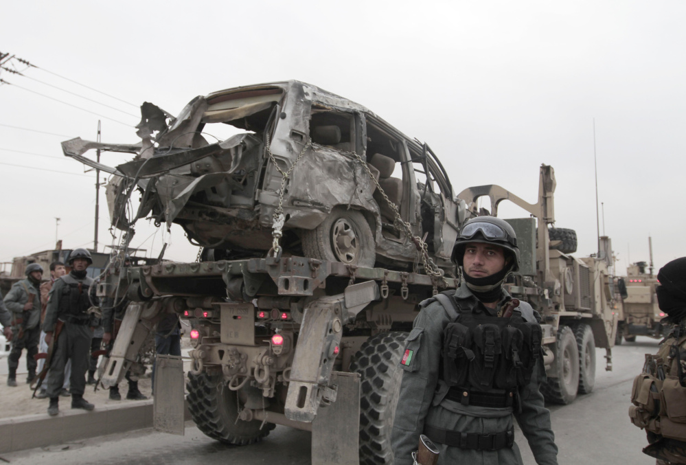 A U.S. military wrecker carries away a vehicle that was destroyed in a suicide car bomb attack on the Jalalabad-Kabul road in Kabul, Afghanistan, on Friday. The U.S.-led coalition in Afghanistan says several service members were killed when a suicide car bomber attacked their convoy in an eastern district of the capital, Kabul.