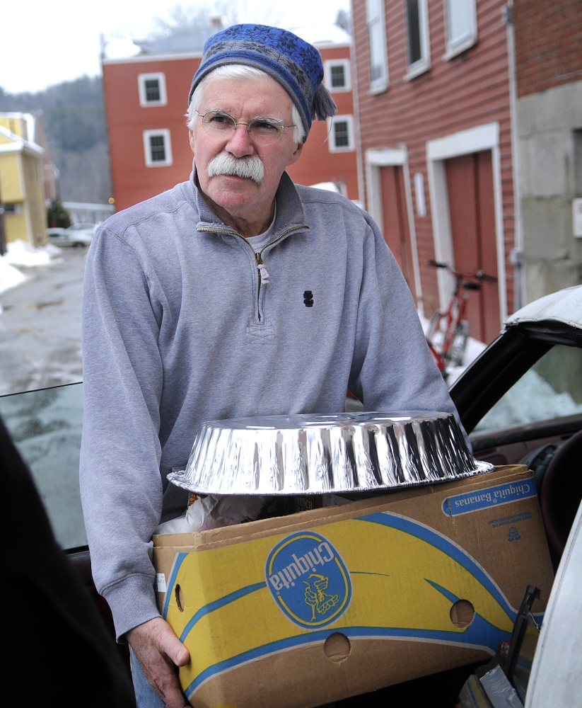 HELPING HAND: Jack Walsh carries a dinner to a customer’s car recently at the Hallowell Food Bank, where he volunteers.