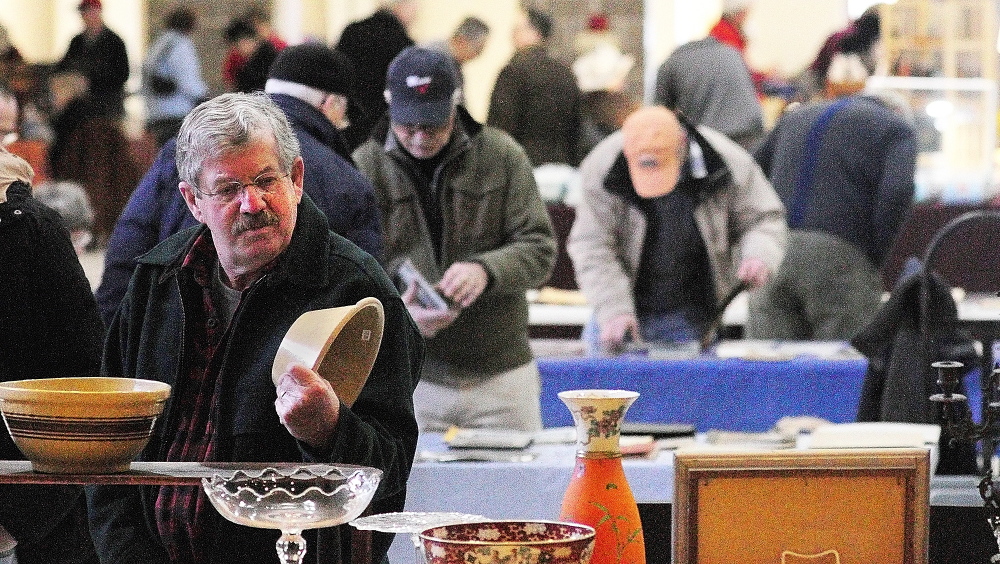 FORAGING: Dennis Ladd, of Farmingdale, looks at a bowl during the New Year’s Antiques Show on Wednesday at the Augusta State Armory.
