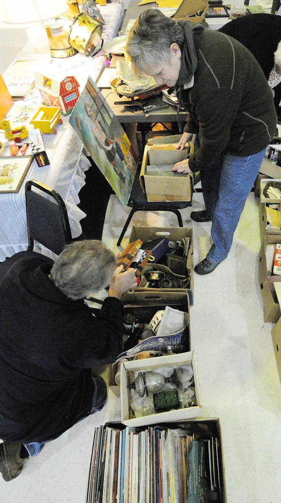 DISCOVERY: Rick Mathiau, bottom, of Vassalboro, shows his wife, Judy Mathiau, something he found in a box during the New Year’s Antiques Show on Wednesday at the Augusta State Armory.