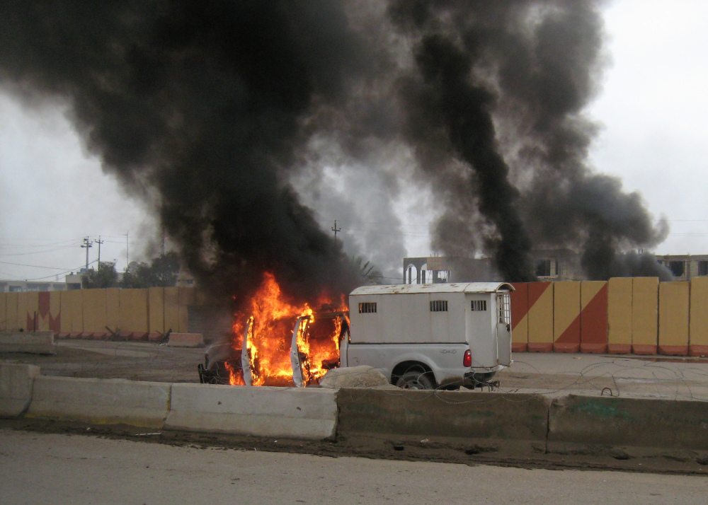 A police truck used to transport prisoners was set afire by al-Qaida fighters after they freed the prisoners, in front of the main provincial government building Wednesday, Jan. 1, 2014. On Wednesday, al-Qaida gunmen fanned out in the streets of towns in the volatile western province of Anbar amid Sunni anger over the arrest of a prominent Sunni lawmaker and the dismantlement of a year-long sit-in the provincial capital Ramadi in recent days.