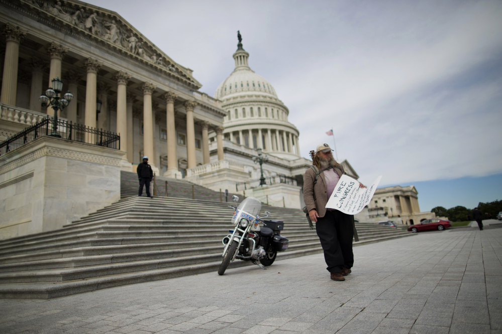 Rick Hohensee of Washington carries a “Fire Congress” sign on Capitol Hill in October. Americans enter 2014 with a negative view of their government, expressing little hope that elected officials can or will solve the nation’s problems.