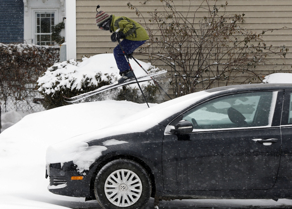 Milo Bloom, 10, skis over a snowbank next to a parked car during a snowstorm Thursday in Portland. Strong winds are creating blizzard-like conditions. A wind chill factor of 30 degrees below zero is expected Friday.