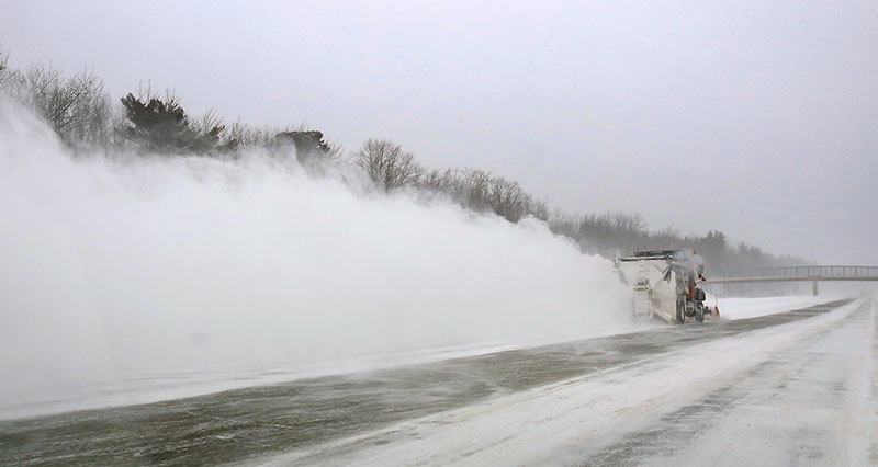 Trailed by a cloud of snow, a snowplow clears part of the Maine Turnpike in Kennebunk on Friday morning.