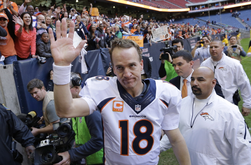 Denver Broncos’ Peyton Manning waves to fans following a Dec. 22, 2013, game against the Houston Texans in Houston. Manning threw his 51st touchdown pass of the season to set a new NFL record.