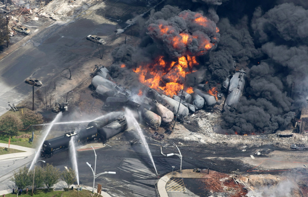 A photo from July 6 shows smoke and flames rising from the debris of a 72-car runaway train that derailed as it transported crude oil at Lac-Megantic, Quebec. Several of the train’s cars exploded, 40 buildings in the town were leveled and 47 people were killed in the disaster.