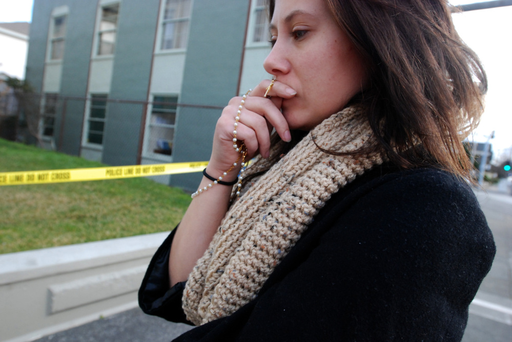 Karli Kauffman of Los Angeles contemplates the death of the Rev. Eric Freed on Thursday outside St. Bernard Catholic Church in Eureka, Calif, where Freed was found slain in the rectory on New Year’s Day.