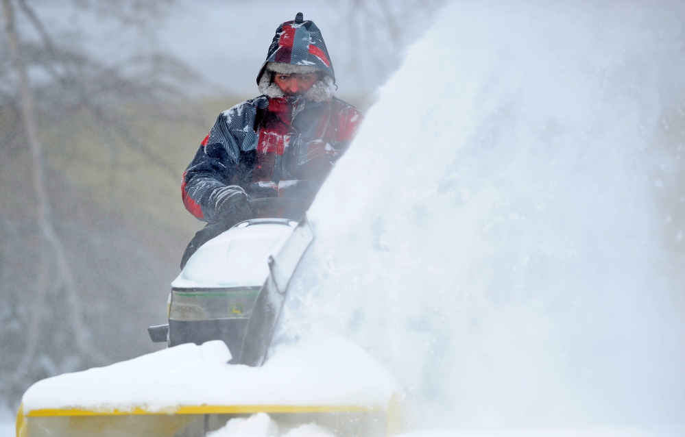 DEEP FREEZE: Mark Douglas clears his Mayflower Hill Road neighbor’s driveway after more snow blankets Waterville on Friday.
