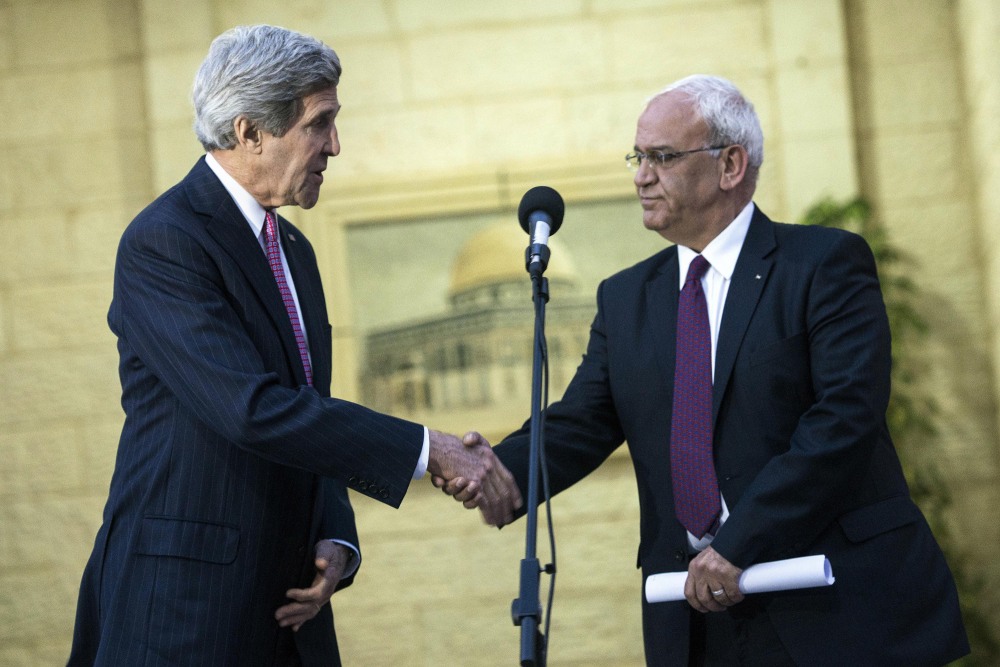 U.S. Secretary of State John Kerry, left, shakes hands with Palestinian negotiator Saeb Erekat during a press conference after meeting with Palestinian President Mahmoud Abbas at the presidential compound in the West Bank city of Ramallah on Saturday. Kerry said Israelis and Palestinians are committed to settling their differences and are working with “great intensity and serious purpose” to achieve that long-sought goal.