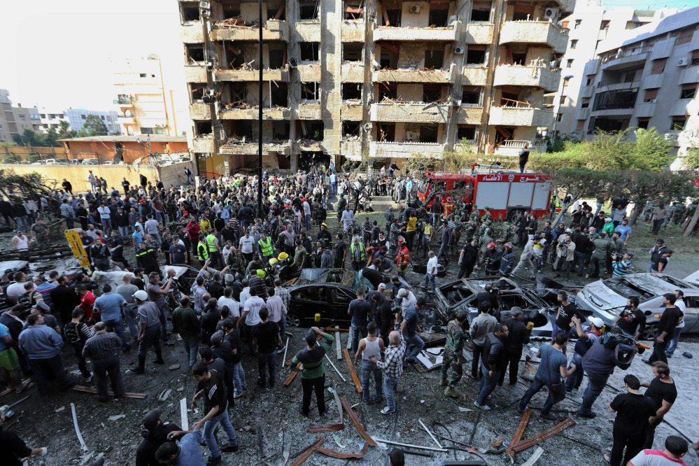 Lebanese people gather at the scene where two explosions have struck near the Iranian Embassy in Beirut, Lebanon. DNA tests confirmed that a man in Lebanese custody is the suspected leader of an al-Qaida-linked group that has claimed responsibility for bombings across the Middle East.