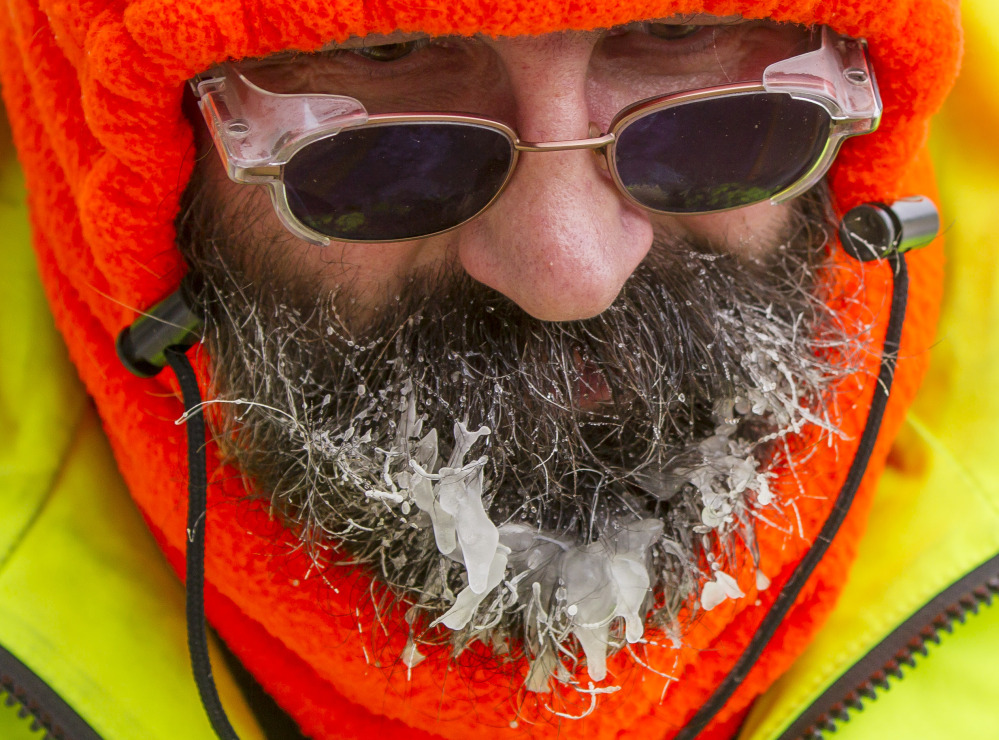 Ice forms on the beard of Bob Schweitzer as he helps clear ice and snow from the seats at Lambeau Field on Friday in Green Bay, Wis., in preparation for Sunday’s wild-card playoff game between the Green Bay Packers and San Francisco 49ers.