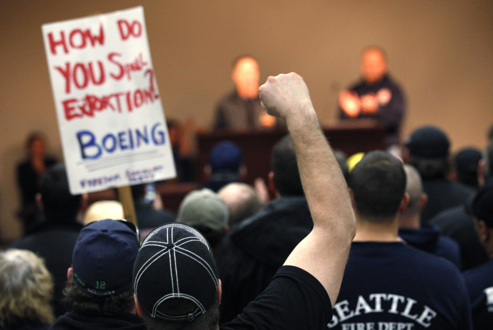 Machinists union members and supporters cheer at a rally asking members to vote against a proposed contract.