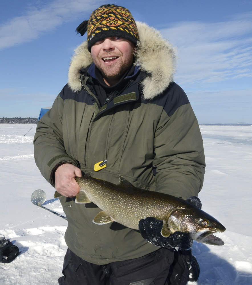 Mike Lorello of South Portland shows a togue, or lake trout, that he caught and then released Saturday during an ice-fishing outing on Sebago Lake.