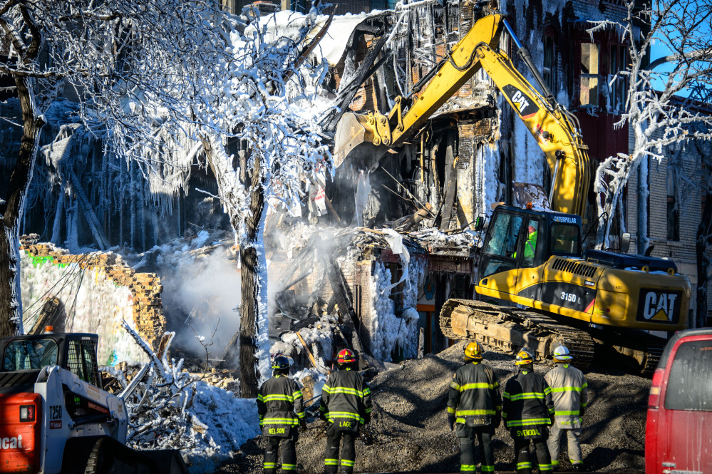 Investigators search for victims from a deadly apartment fire in Minneapolis. (AP Photo/The Star Tribune, Glen Stubbe)