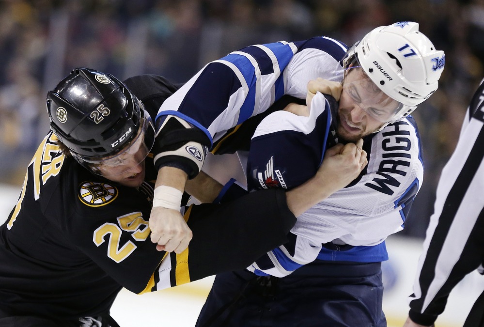 Matt Fraser of the Bruins, left, and Winnipeg’s James Wright fight in the first period Saturday in Boston. The Bruins won, 4-1.