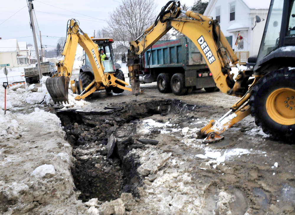 BURST: Workers dig up a portion of Oak Street in Waterville that was closed most of Sunday after a water main break sent water flooding on to Oak Street and Drummond Avenue. Bob Durand of Kennebec Water District said the reason for the flooding or the exact location of the break had not been determined by late afternoon.