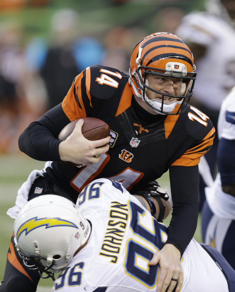 Cincinnati Bengals quarterback Andy Dalton (14) is tackled by San Diego Chargers linebacker Jarret Johnson in the second half of an NFL wild-card playoff football game on Sunday, Jan. 5, 2014, in Cincinnati. (AP Photo/Al Behrman)