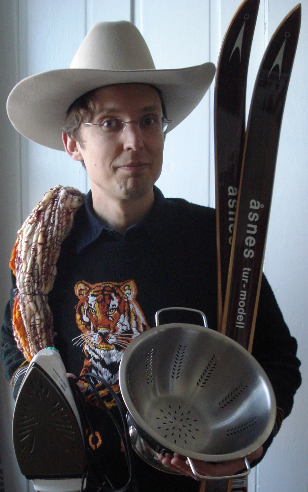 AUCTION ITEMS: Dugan Murphy, executive director of Main Street Skowhegan, poses Friday with some of the items to be auctioned in March to benefit the Skowhegan Indian restoration project. The theme of the auction is unwanted Christmas gifts.