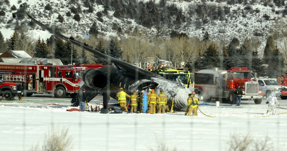 Emergency crews work near a passenger plane that crashed upon landing at the Aspen-Pitkin County Airport in Aspen, Colo., Sunday,
