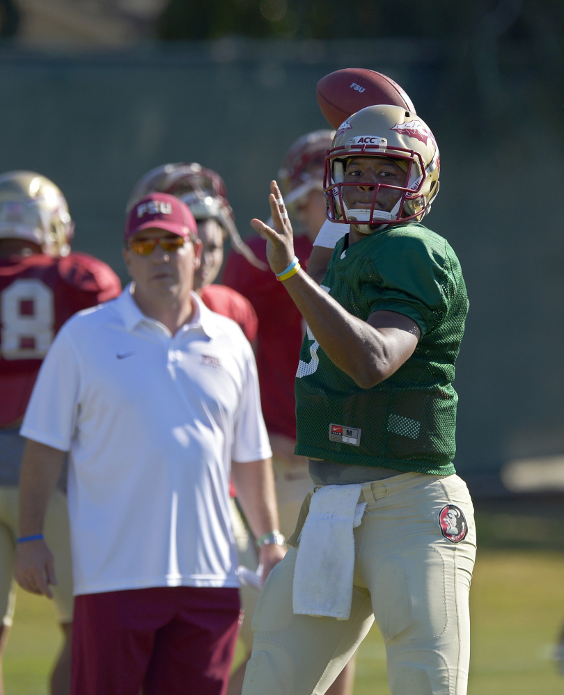 Florida State quarterback Jameis Winston, right, passes as head coach Jimbo Fisher looks on during practice for their BCS Championship game against Auburn, Thursday, Jan. 2, 2014, in Costa Mesa, Calif. (AP Photo/Mark J. Terrill)