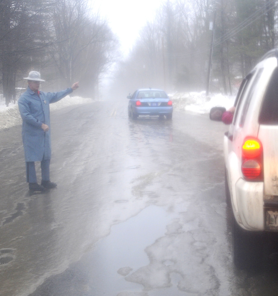 ELEMENTS: State Trooper Sam Tlumac directs traffic away from icy roads Monday morning on Northern Avenue in Farmingdale. Drivers encountered icy roads slickened by rain compelling authorities to close several roads across the state.