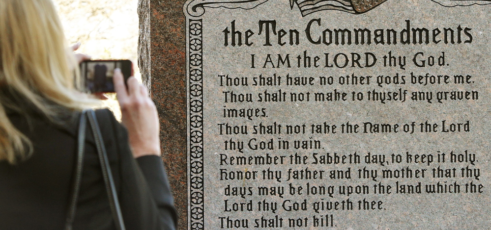 A woman takes a picture of a granite monument engraved with the Ten Commandments after it was erected on the north side of the state Capitol grounds in Oklahoma City in 2012. A group of New York-based Satanists now want to erect their own monument depicting a goat-headed deity.